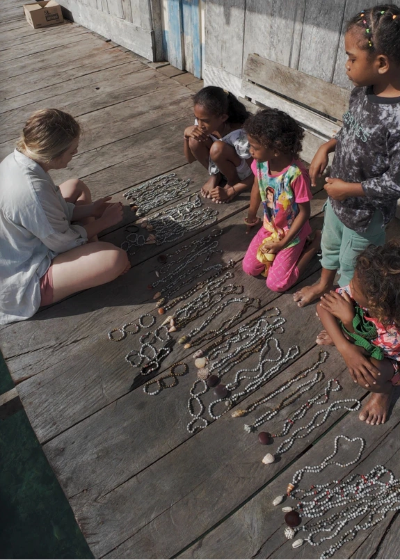 Wayag Islands – Jak Zorganizować Wycieczkę? Piaynemo vs. Wayag na Raja Ampat Lokalna społeczność na Raja Ampat dzieci sprzedające biżuterię z muszelek w jednej z wiosek na rajskiej wyspie