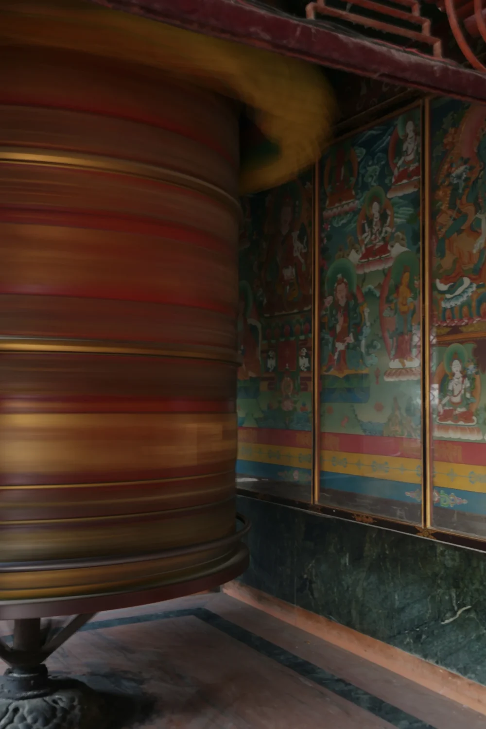 Boudhanath-Stupa-Khatmandu-Nepal-mlynek-modlitewny-buddyzm-zwiedzanie-atrakcje Detal wnętrza świątyni przy Boudhanath – młynek modlitewny w ruchu i tybetańskie malowidła ścienne