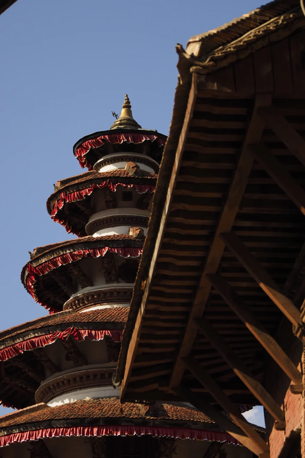 Katmandu-Durbar-Square-Hanuman-Dhoka-Nepal-Atrakcje-Przewodnik-Zwiedzanie-Co-Robic-Podroze-Azja Szczegóły architektury świątyni na Durbar Square w Katmandu – tradycyjna pagoda z czerwonymi zdobieniami i drewnem rzemiosłem newarow