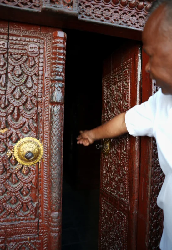 Kumari-Ghar-Swiatynia-Durbar-Square-Katmandu-Stolica-Nepal-Co-Robic-Atrakcje-Przewodnik-Zwiedzanie-Azja Wejście do świątyni żywej bogini Kumari Ghar w Katmandu Bogato zdobione drewniane drzwi i przewodnik zapraszający do środka