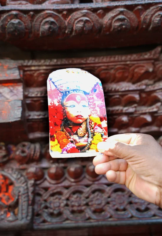 Kumari-Zywa-Bogini-Nepal-Atrakcje-Durbar-Square-Zwiedzanie-Podrozowanie-Przewodnik-Swiatynia-Kumari-Ghar-Buddyzm-Hinduizm Fotografia Kumari – żywej bogini Nepalu, na tle tradycyjnych rzeźbień świątyni Kumari Ghar w Durbar Square