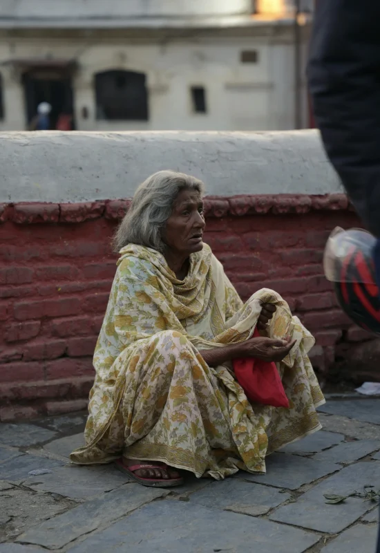 Pashupatinath-Katmandu-Ludzie-Ulicy-Street-Photo-Przewodnik-Nepal-Travelbymonkey Kobieta w kwiecistym sari siedząca na ulicy w pobliżu kompleksu Pashupatinath – scena z codzienności Katmandu”